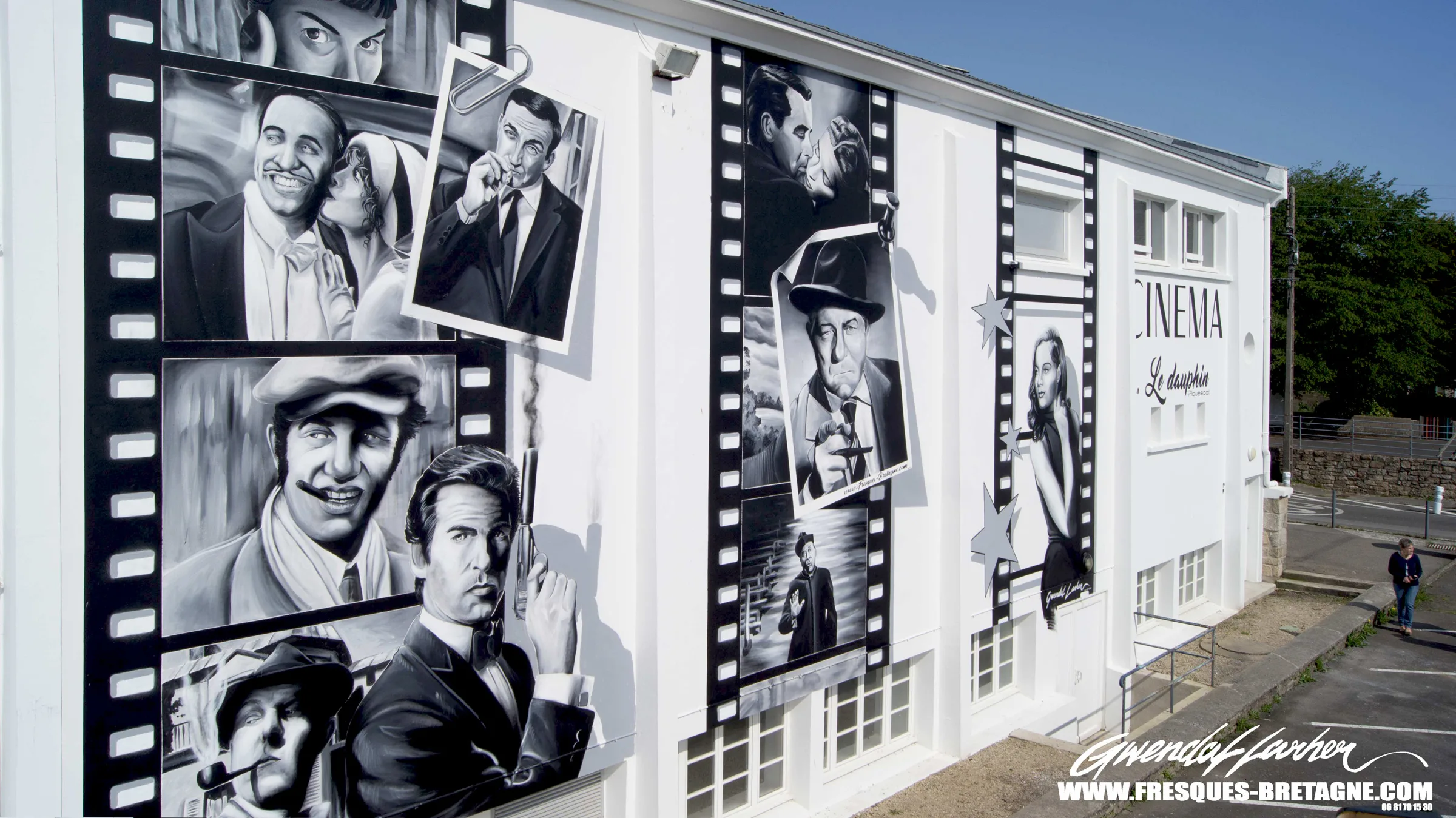 Fresque monumentale de street art sur la façade du cinéma Le Dauphin à Plouescat, portraits d'acteurs en noir et blanc sur des pellicules géantes